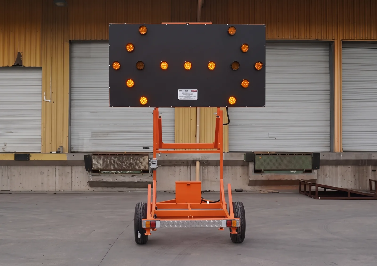 Carro panel flecha LED solar TEC-2415 con el panel ámbar levantado, sobre su estructura naranja de transporte.