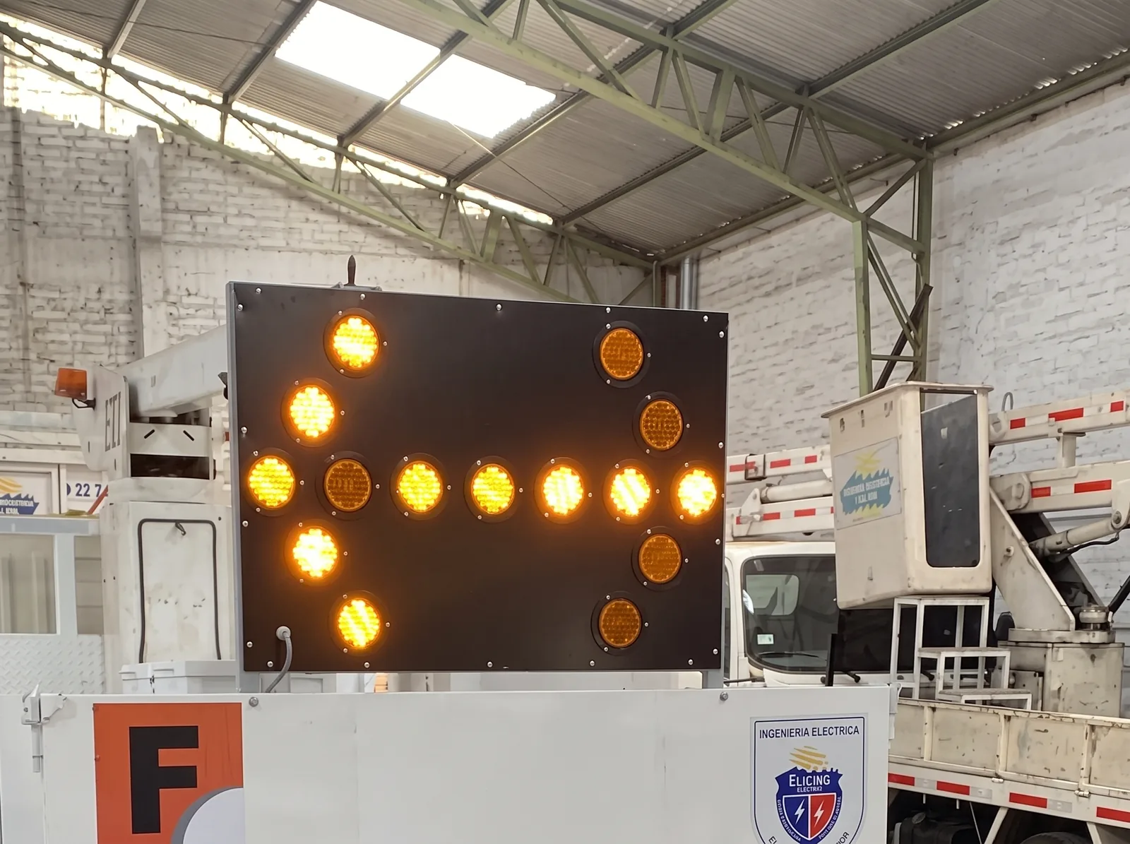 Panel flecha LED encendido montado sobre un camión de servicio eléctrico.