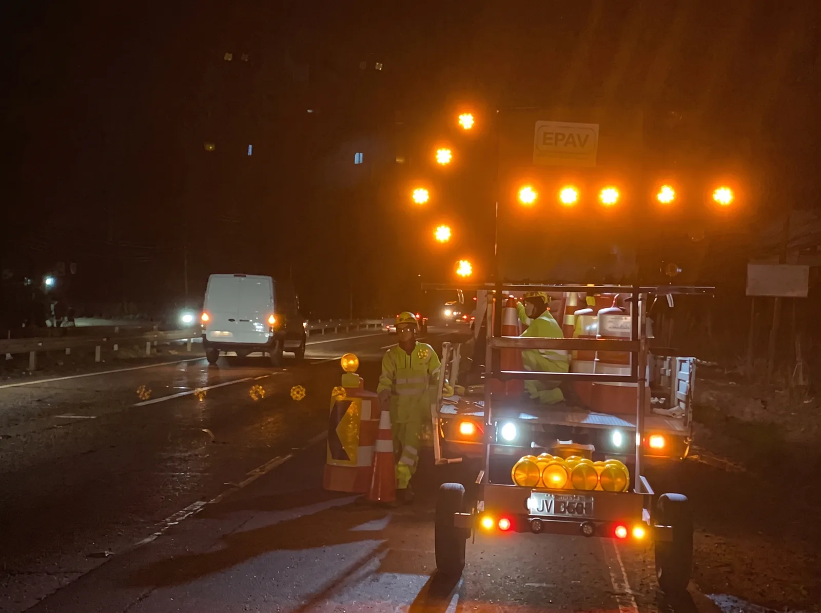 Faena nocturna en carretera: panel flecha LED encendido sobre un vehículo de TECGVIAL y un operario con ropa reflectante.