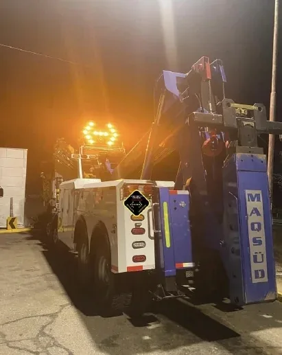 Camión grúa de rescate con el panel flecha LED TEC-1115 encendido sobre la pluma, durante un turno de noche.